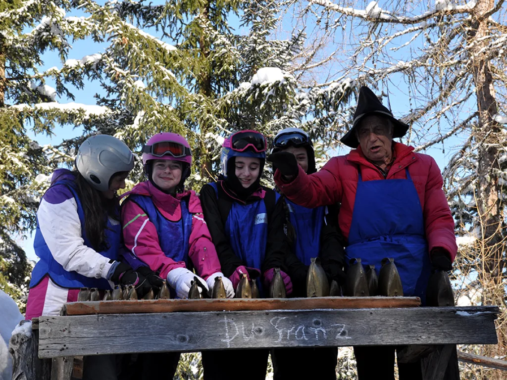 Gruppe steht an der Glockenreihe vor der Hütte.
